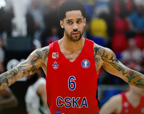 Баскетболист в форме ЦСКА с номером 6. У него тёмные волосы и татуировки на руках. На заднем плане видно размытую трибуну с ярко одетыми зрителями